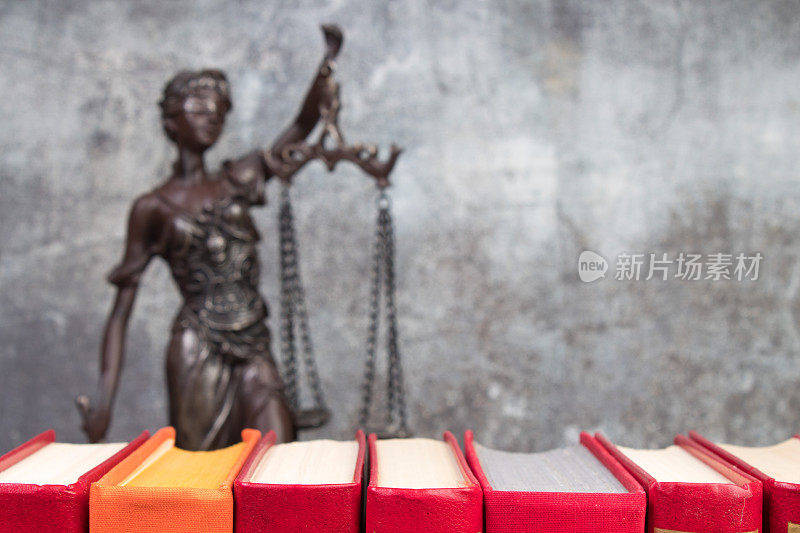 法律概念-打开法律书秤，法庭或执法办公室桌子上的忒弥斯雕像。