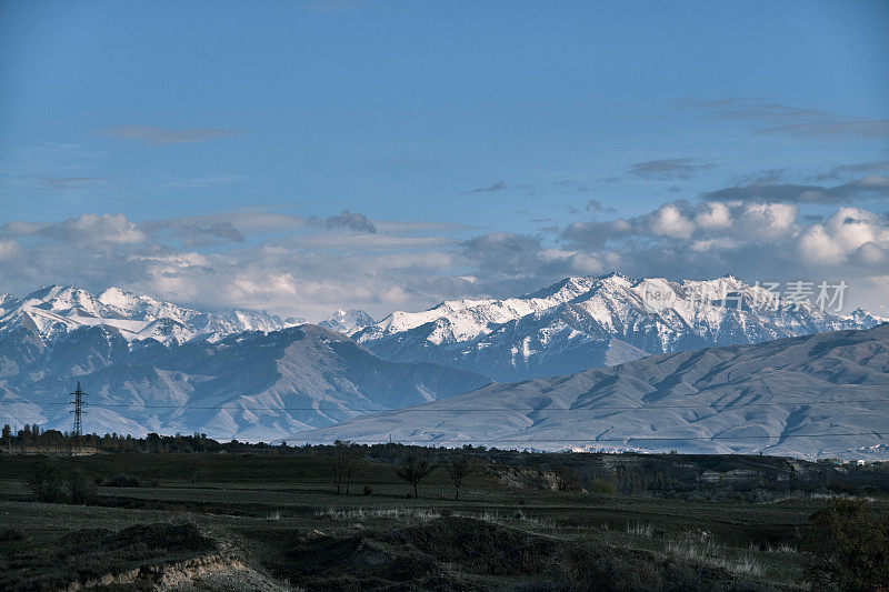 黑暗的山麓和云层下明亮的雪山