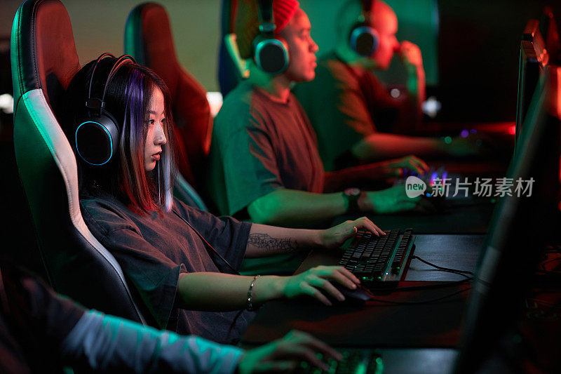 戴着耳机玩电子游戏的亚洲女性