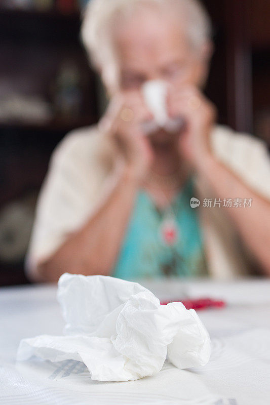 患流感的老妇人用手帕擤鼻涕