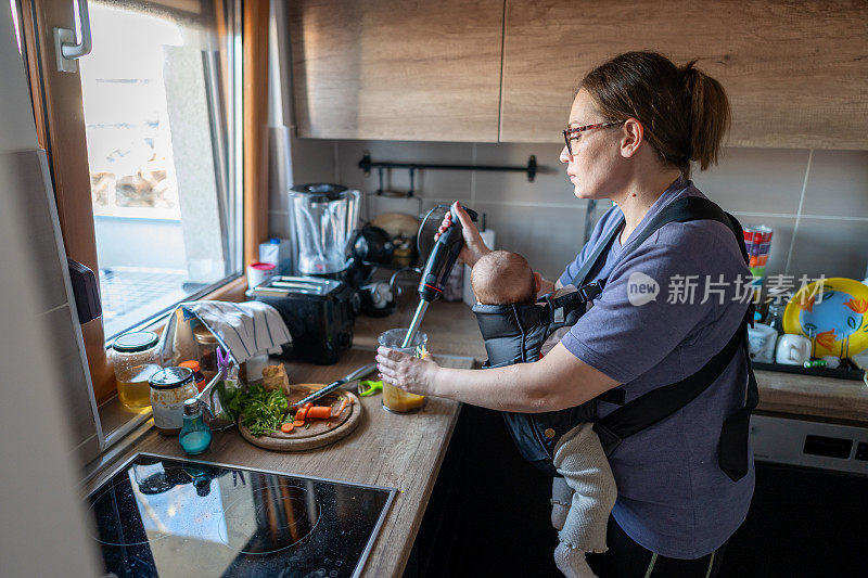 母亲用搅拌器给婴儿准备食物