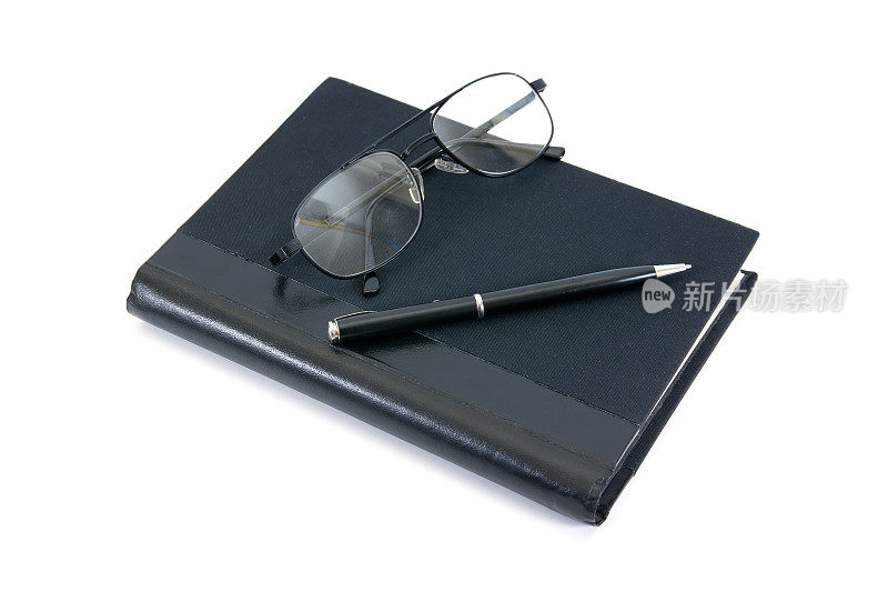 钢笔、书和眼镜孤立在白色的背景上