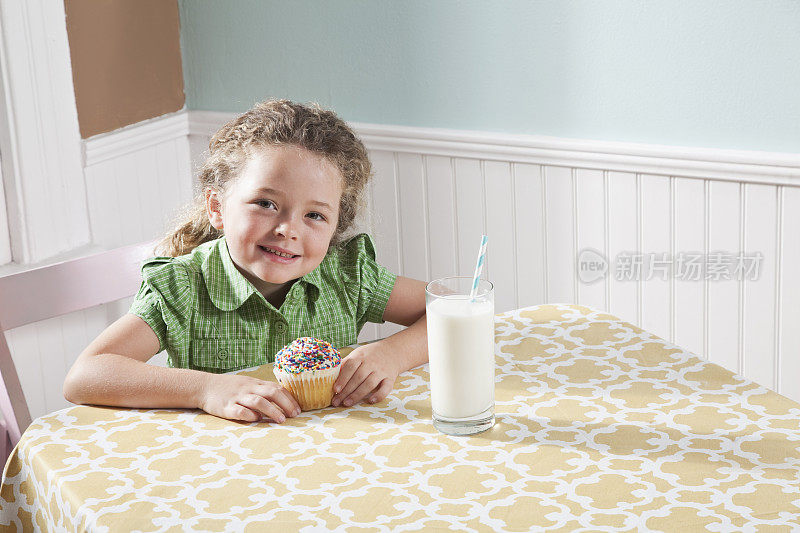 一个拿着牛奶和蛋糕的小女孩