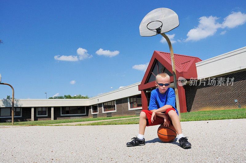 小男孩在学校篮球场上