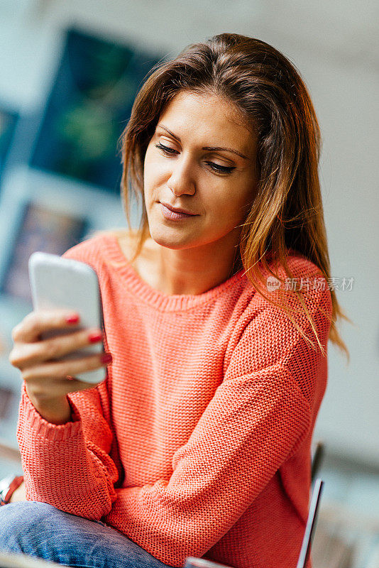 漂亮女人用智能手机喝咖啡的肖像