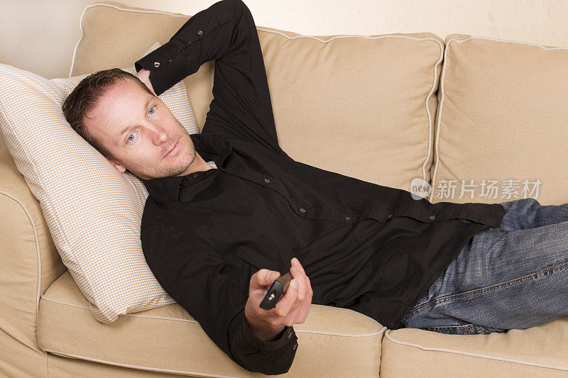 一个男人懒洋洋地躺在沙发上