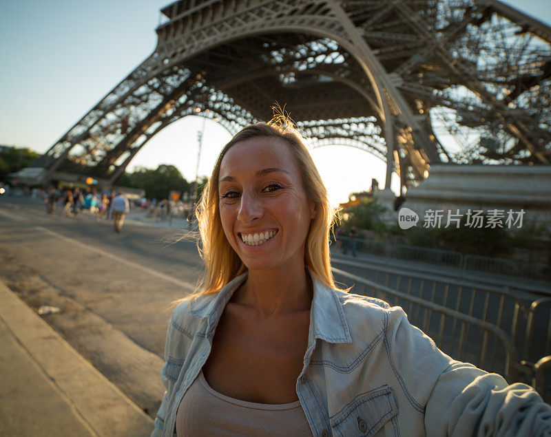 一名兴高采烈的年轻女子在巴黎埃菲尔铁塔自拍