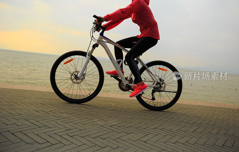 健康的生活方式年轻女子骑自行车在海边