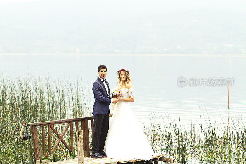 新娘和新郎在湖边的码头摆造型
