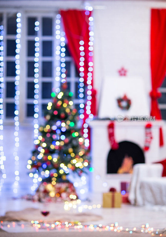 散焦圣诞灯，树和壁炉的家庭背景