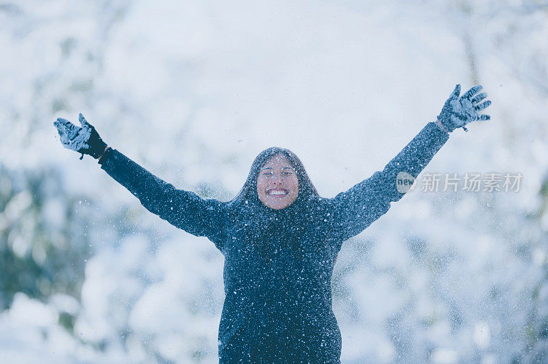 年轻女子在雪中玩耍