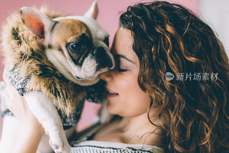 一个自信的女人抱着一只法国斗牛犬