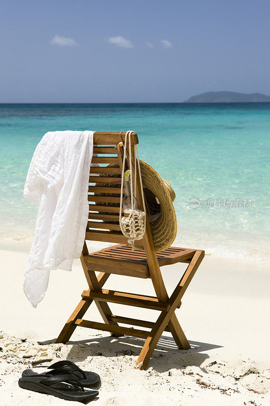 椅子，帽子，衬衫，凉鞋和啤酒在加勒比海滩