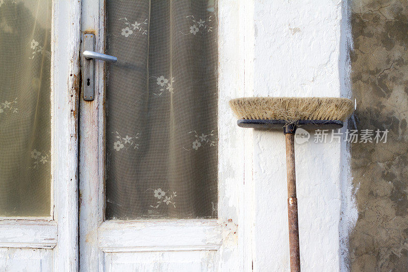 意大利，迷人的白色老门口，带花边窗帘和扫帚