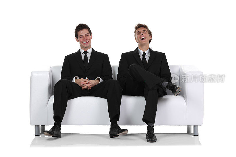 两个商人坐在沙发上大笑