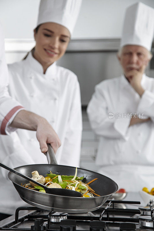 厨师用平底锅煮蔬菜。