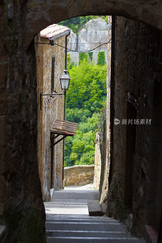 皮蒂利亚诺，托斯卡纳，意大利:狭窄的小巷俯瞰绿色山谷
