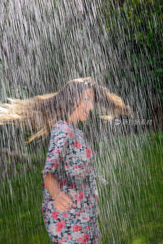 女人享受雨在日落