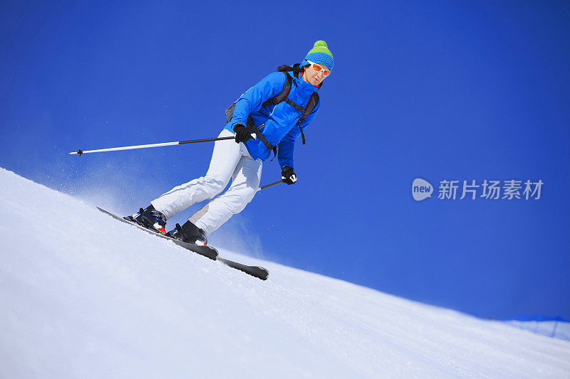 在阳光明媚的滑雪胜地滑雪的中年妇女滑雪