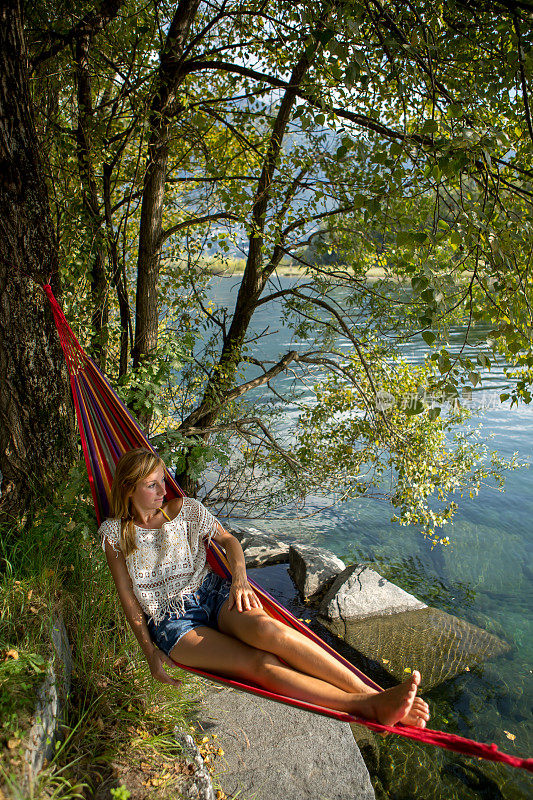 一个女人在河边的吊床上休息
