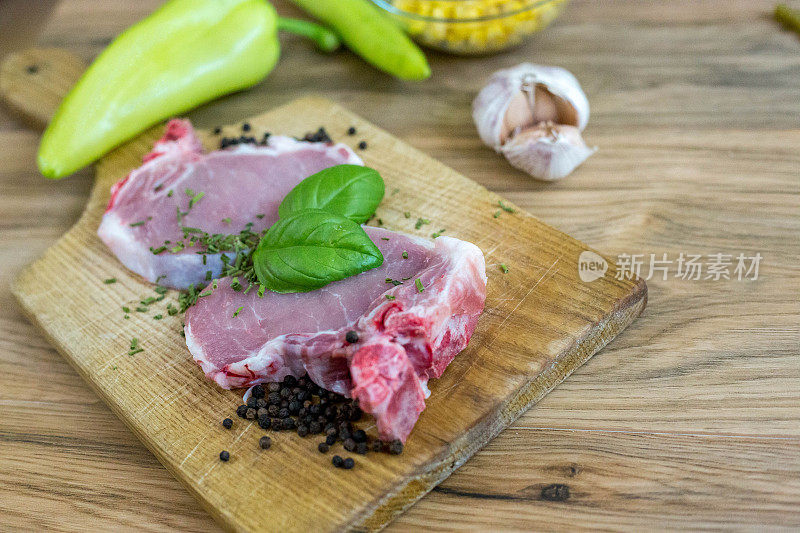 食物。切片的生肉烧烤与新鲜蔬菜肉生牛排。牛排烧烤。西红柿，辣椒，煮肉用的香料。