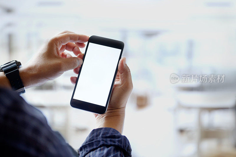 模拟图像的男人手握黑色手机与空白白色屏幕在办公室。