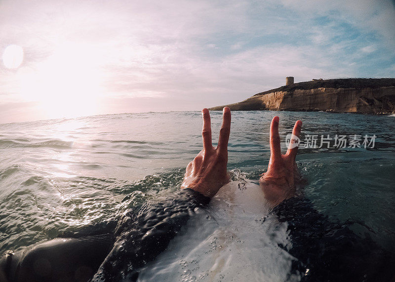 冲浪者双手在海里做和平手势(POV)