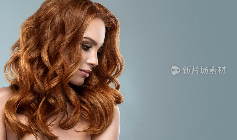 红头发的女人，有着丰满的，有光泽的和卷曲的发型。飞行的头发。