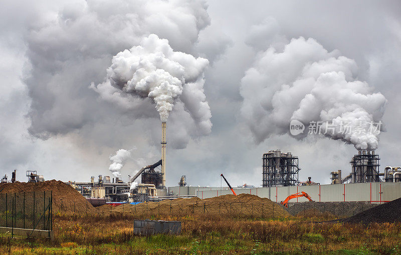 来自工业烟雾的大气污染。管道钢铁厂。中密度纤维板生产中的浓烟和蒸汽。阴雨天工作。环境污染。