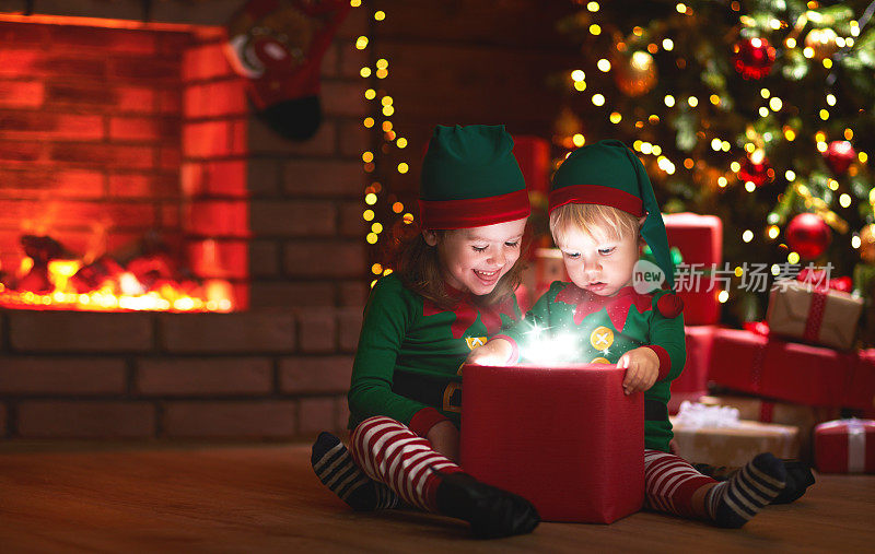 圣诞节。小精灵们在圣诞树和壁炉旁带着一份神奇的礼物