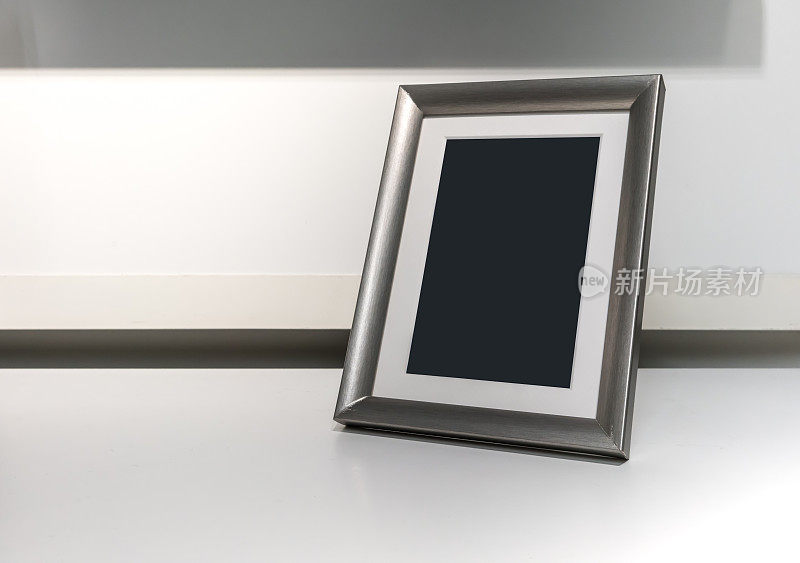 黑色空间上的垂直银色铝框架上的白色桌子