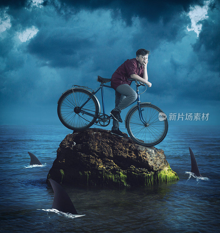 一个骑自行车的年轻人站在大海中央的一块岩石上，周围都是鲨鱼。