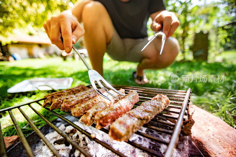 年轻人在烧烤上烤肉