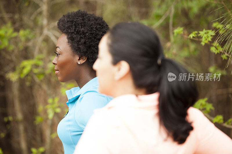 两个女性朋友在附近的公园里跑步。