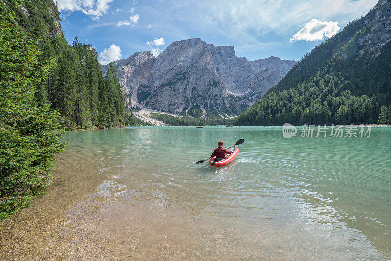 意大利，一名年轻人在布雷斯湖上划着红色的独木舟