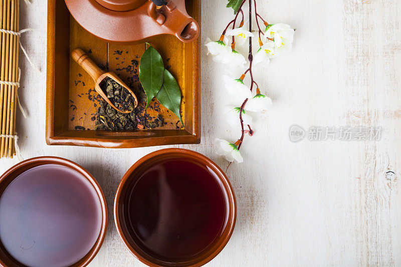 陶瓷茶壶、茶叶和樱花