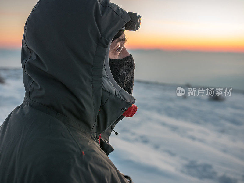 肖像拍摄的冒险家探险家在户外的山区看日落