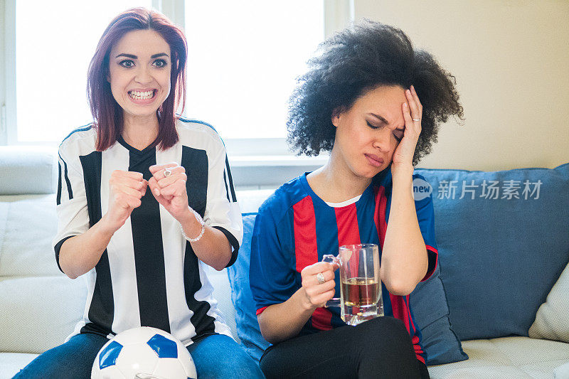 兴奋的红发女子和她的朋友用手捂着脸一起看足球比赛