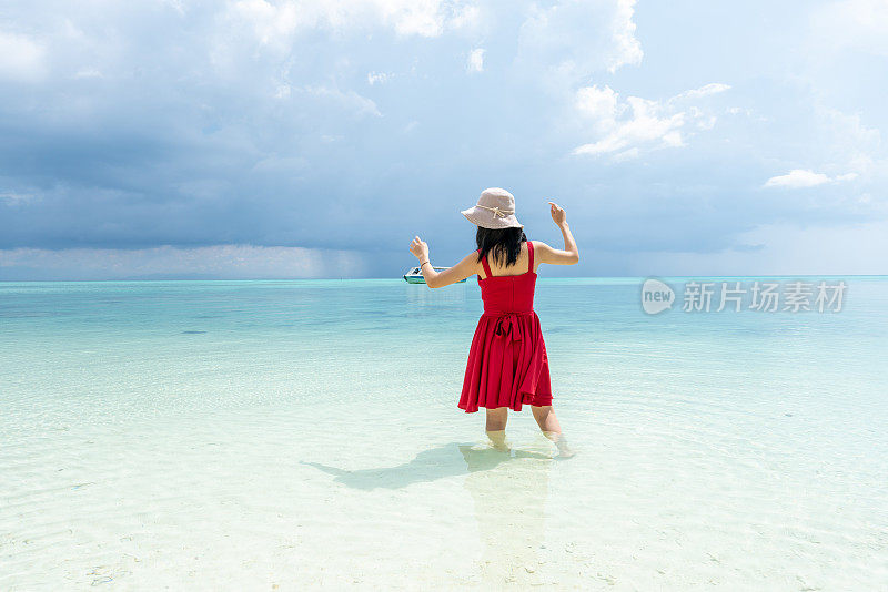 一个女孩在海滩上穿着红色的衣服