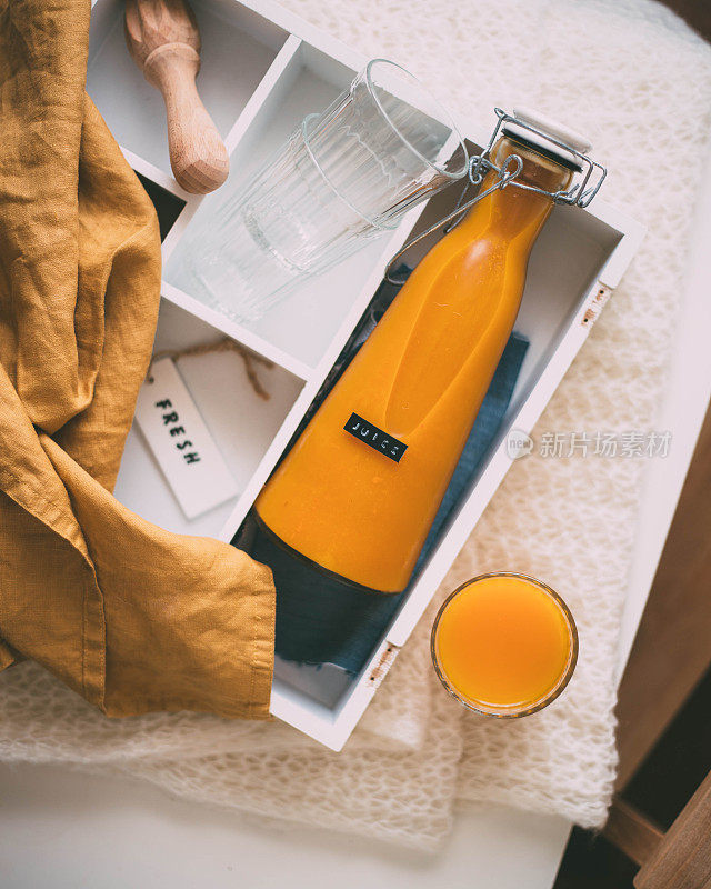 木桌上放着一瓶橙汁。空准备你的橙汁，水果产品展示或蒙太奇。