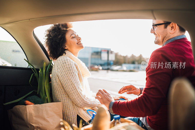 年轻夫妇在车里放杂货