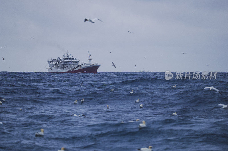 在波涛汹涌的海面上出海的拖网渔船