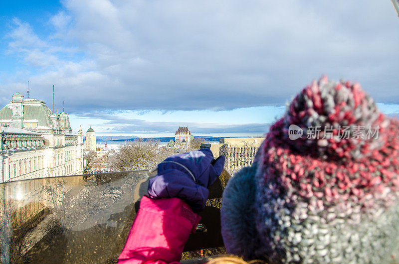 年轻的女孩在看伟大的高角度的魁北克市区在一个冬天的一天