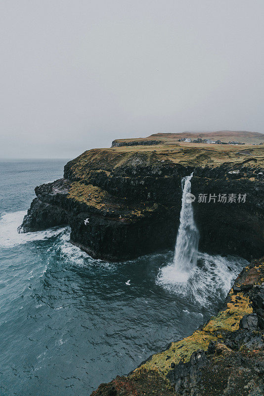 在法罗群岛的风景Múlafossur瀑布坠入大海