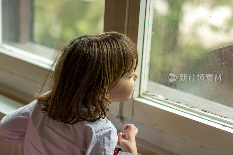 小女孩从窗户往里看