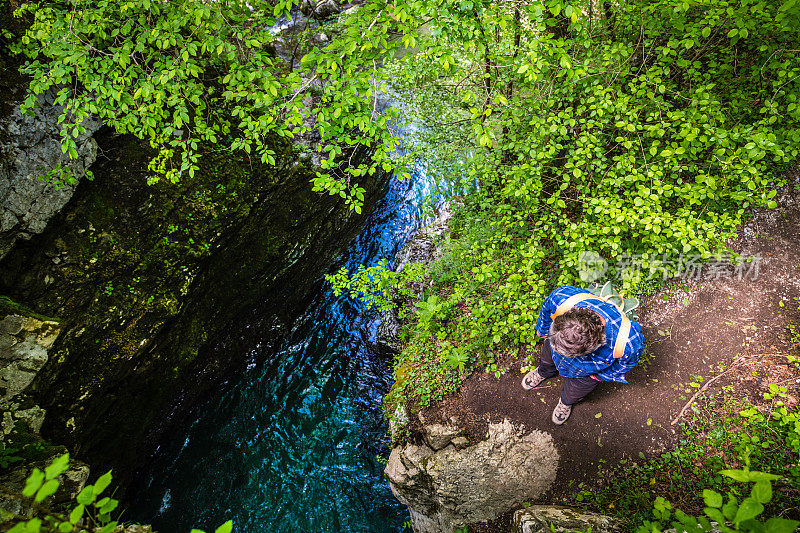 在斯洛文尼亚科巴里德附近的朱利安阿尔卑斯山，一名男子正在欣赏令人惊叹的科兹贾克峡谷小路