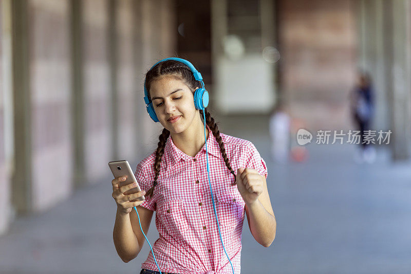 少女走在街上听着音乐