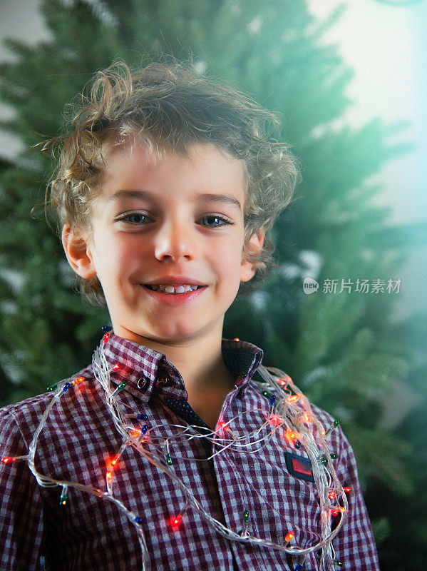 一个戴着圣诞彩灯的小男孩的肖像