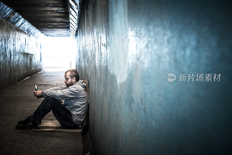 无家可归的年轻人坐在冰冷的地铁隧道里