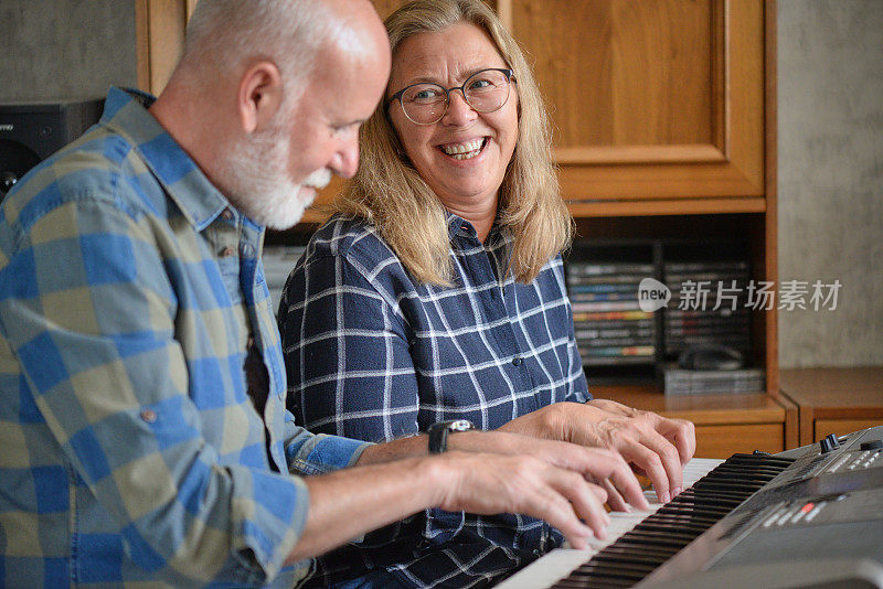 一对迷人的夫妇在家里弹钢琴
